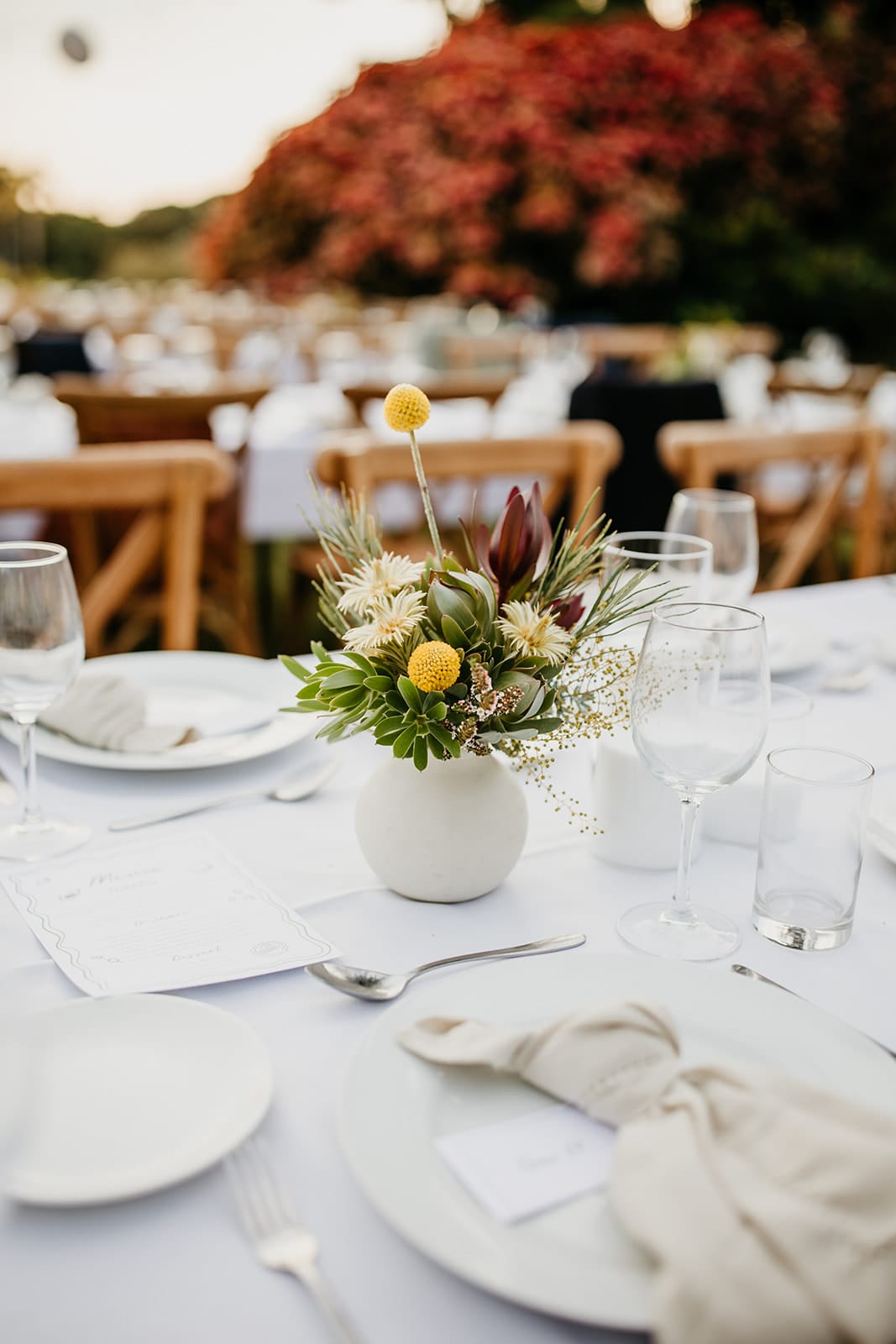 Decorative table setting with flowers and cutlery on a white tablecloth.