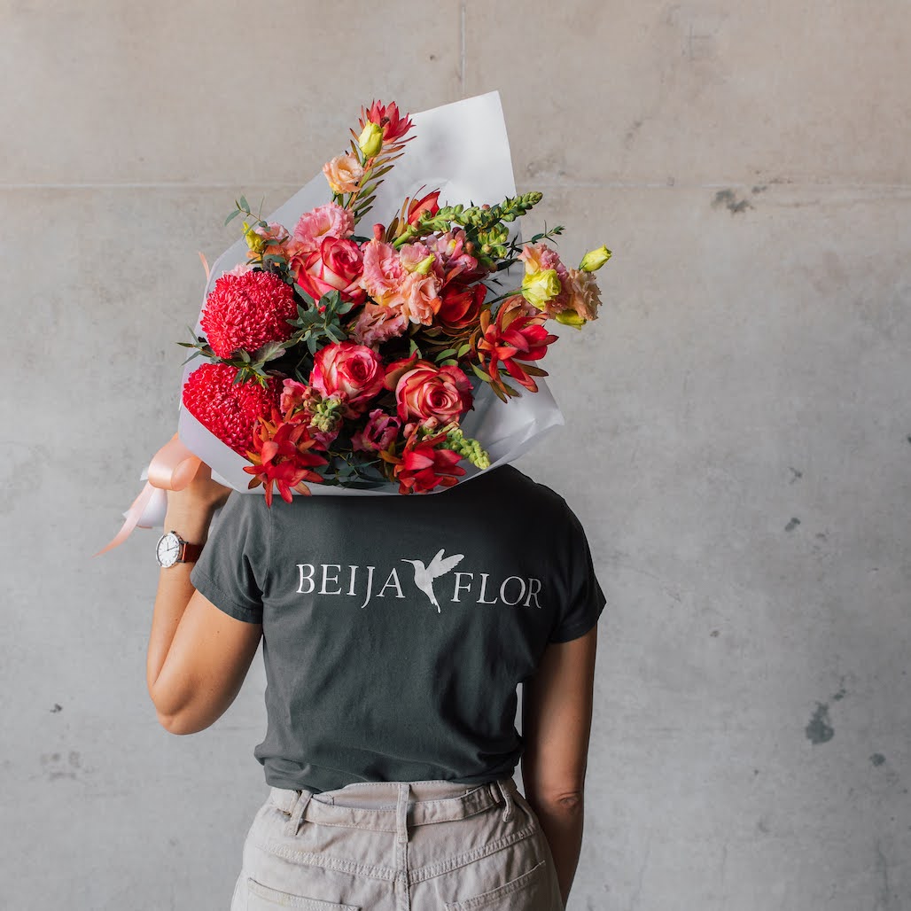 Person holding bright pink gift wrapped bouquet