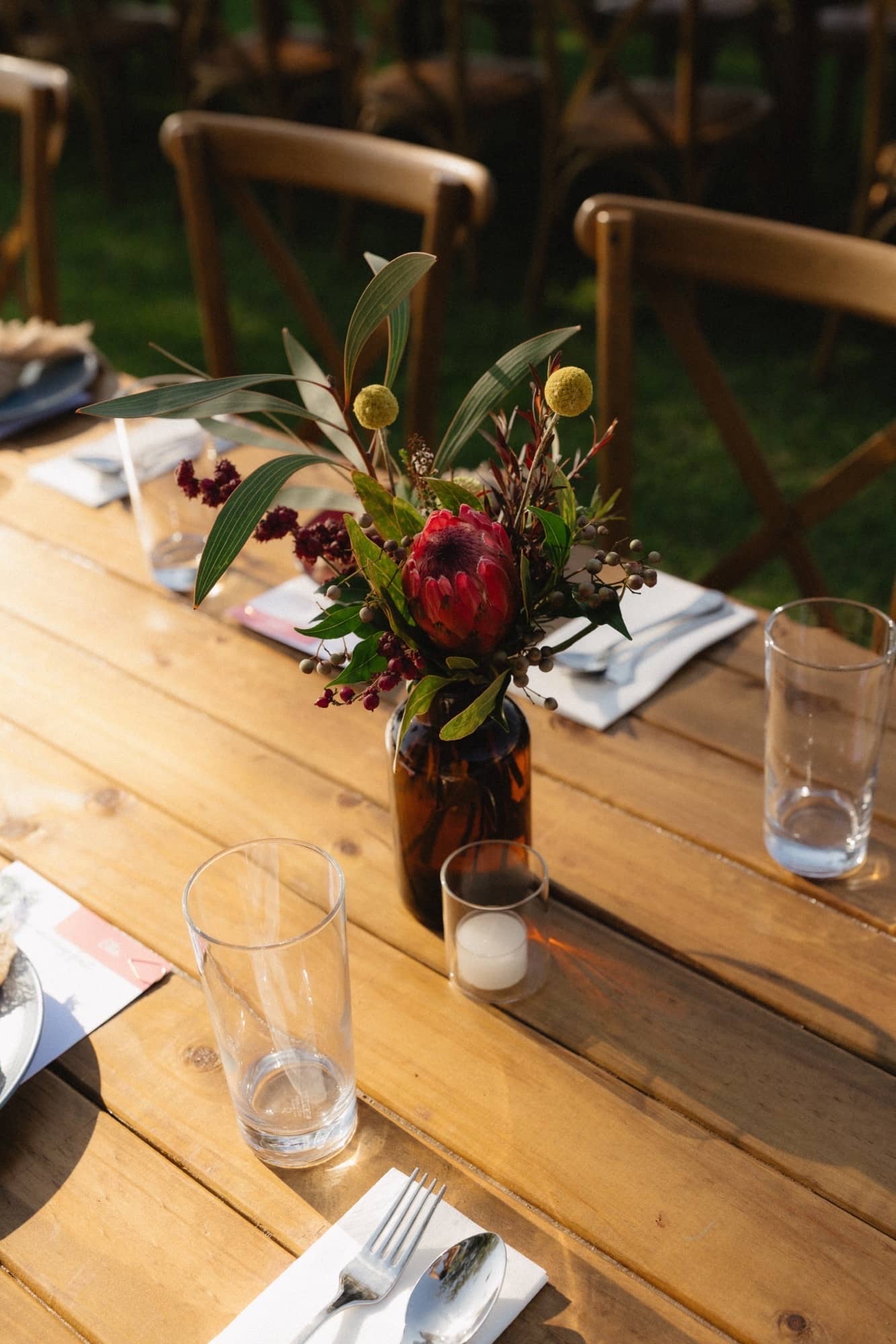 amber specimen bottles topped with native blooms for a outdoor Darwin wedding