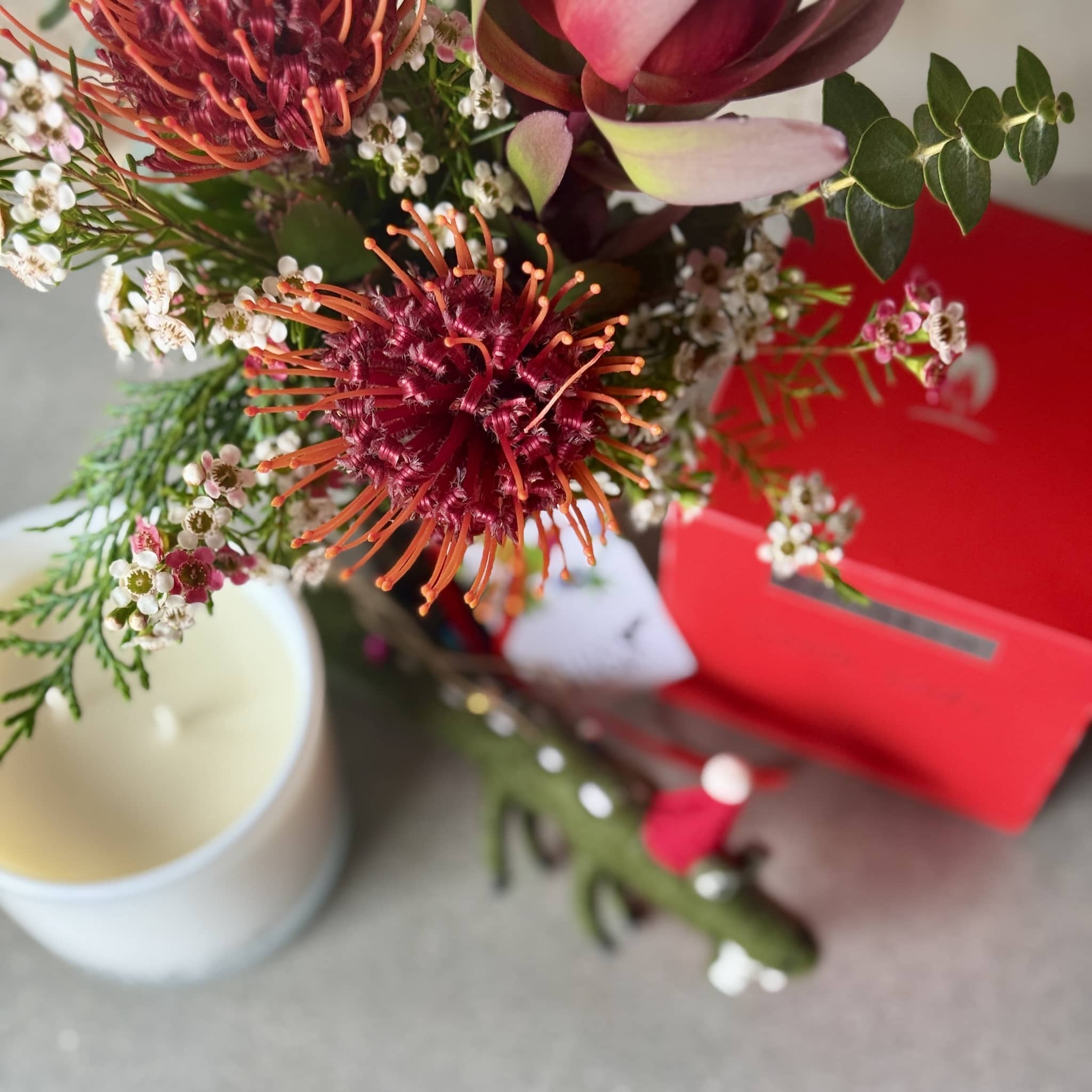 Jar of festive flowers with scented candle and a crocodile ornament