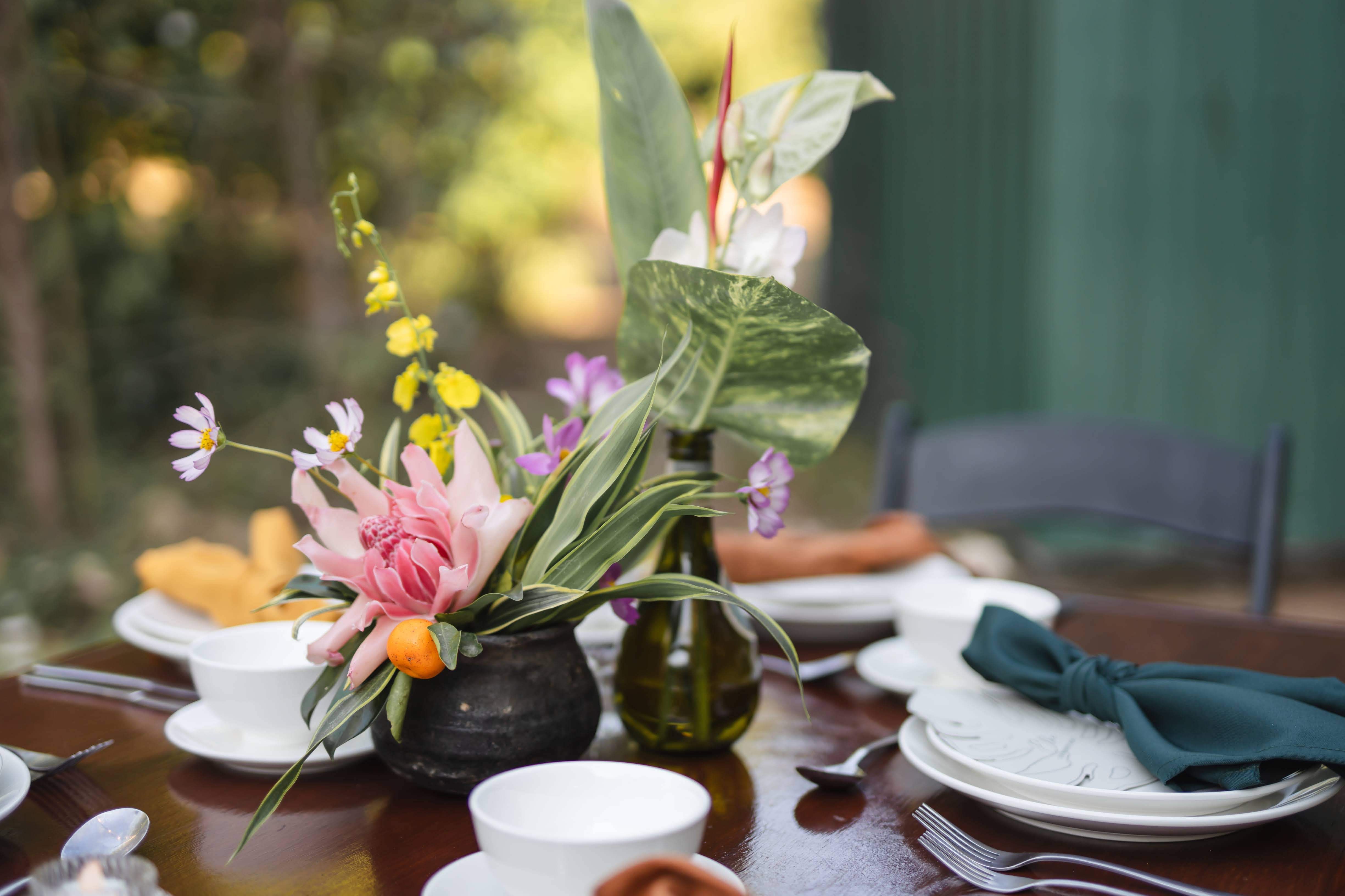 Kayla and Russell Beija Flor Real Wedding Floral centerpiece with proteas and greenery on a table