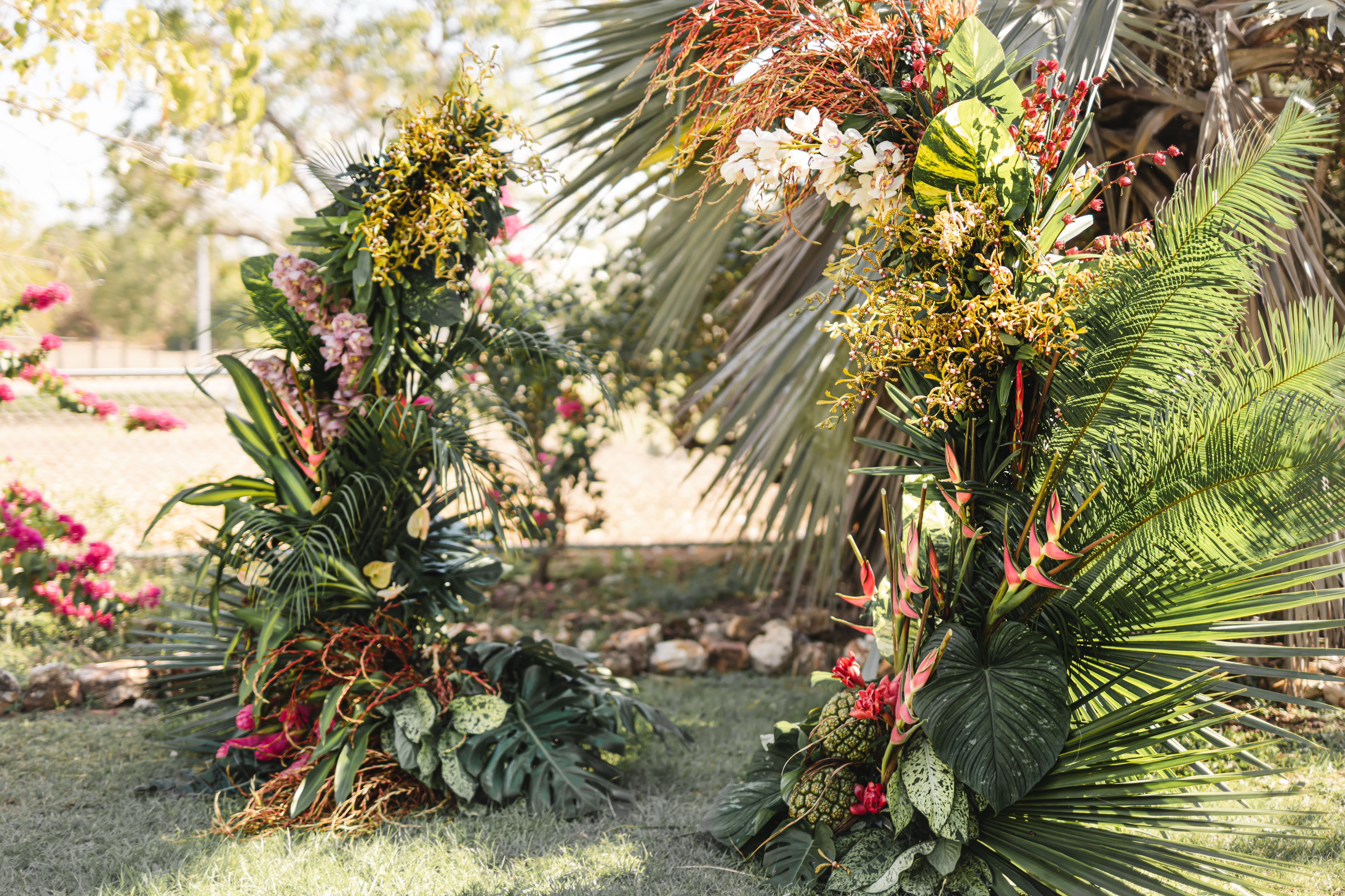 Kayla and Russell Beija Flor Real Wedding Tropical arbour with vibrant flowers and palm leaves