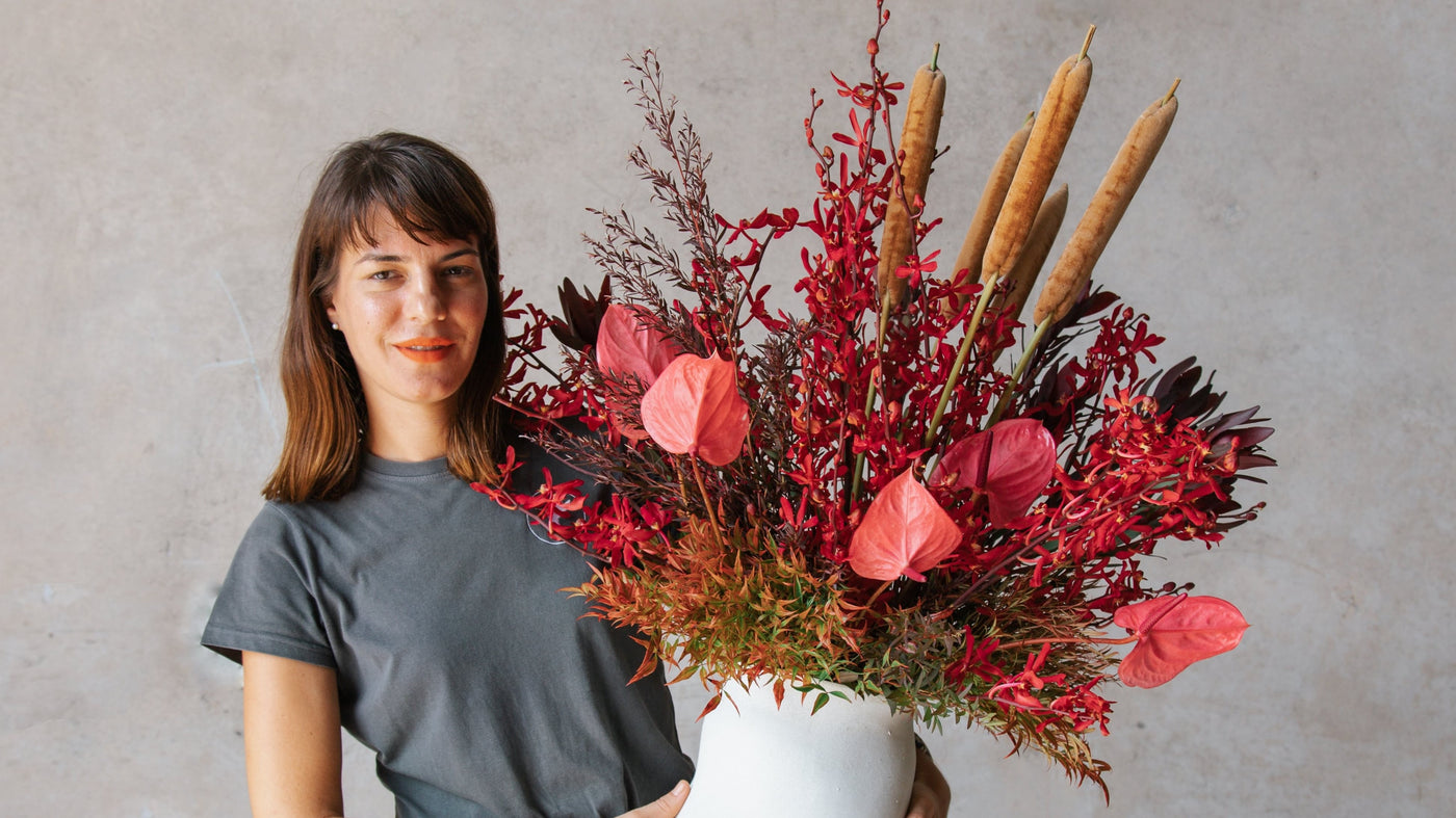 Meet the team Maria Okwa Beija Flor's Owner and Creative Director holding a vase arrangement