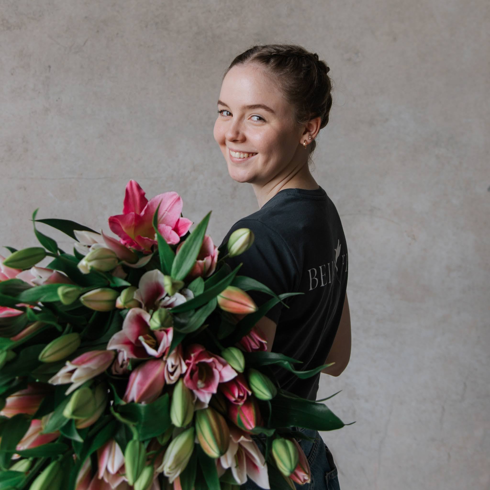 Mary Fryar Beija Flor Florist holding a bunch of florals