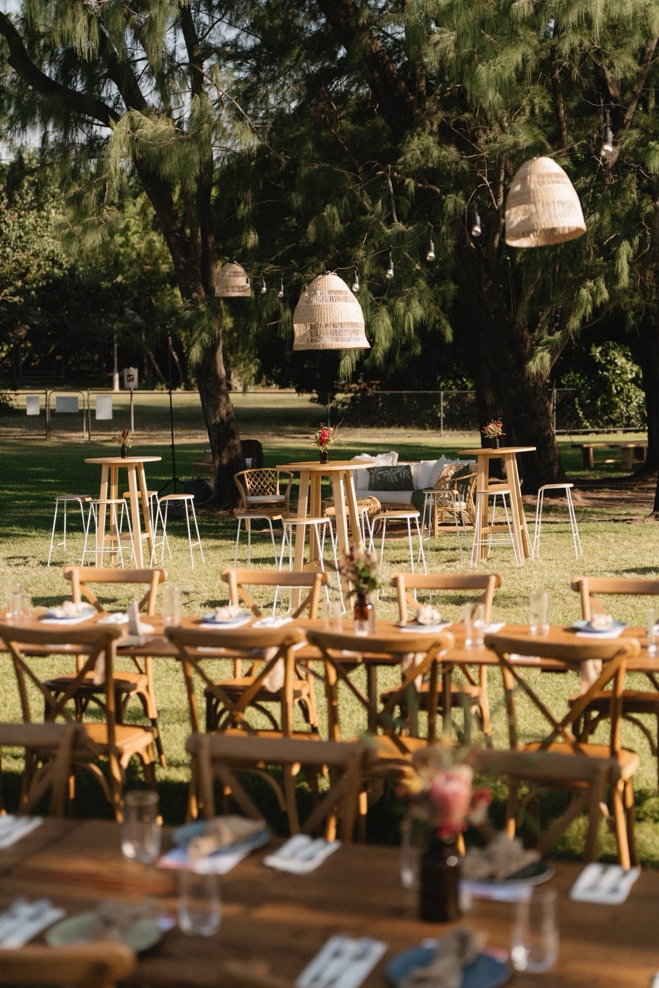 Amber specimen bottles topped with native flowers at an outdoor Darwin wedding at the Surf Lifesaving Club