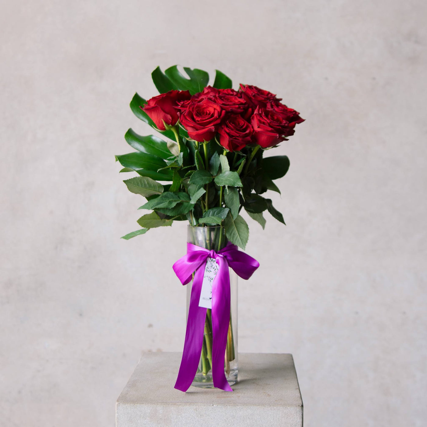 Beija Flor Valentines Day Dozen Rose Vase Tied in Purple Ribbon