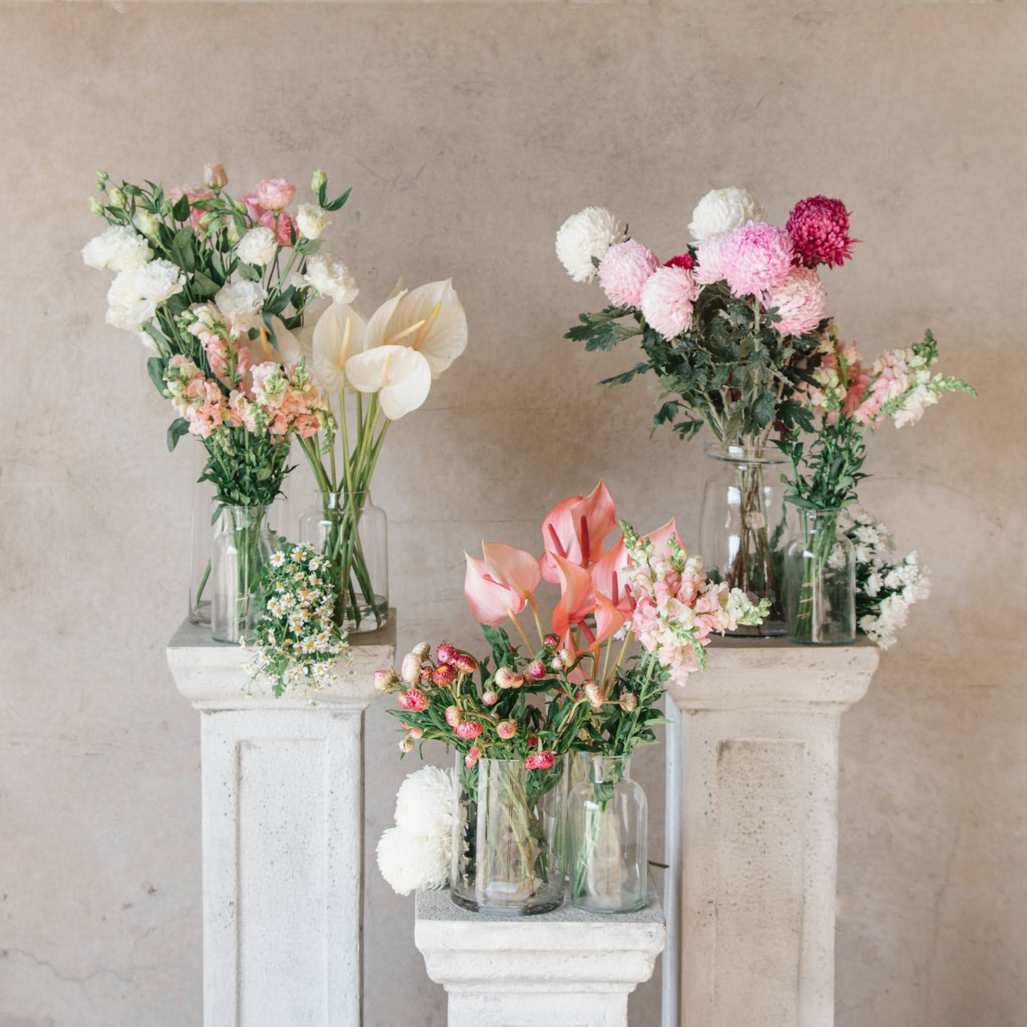 Stone plinths with jars of pink flowers Beija Flor Darwin Florist