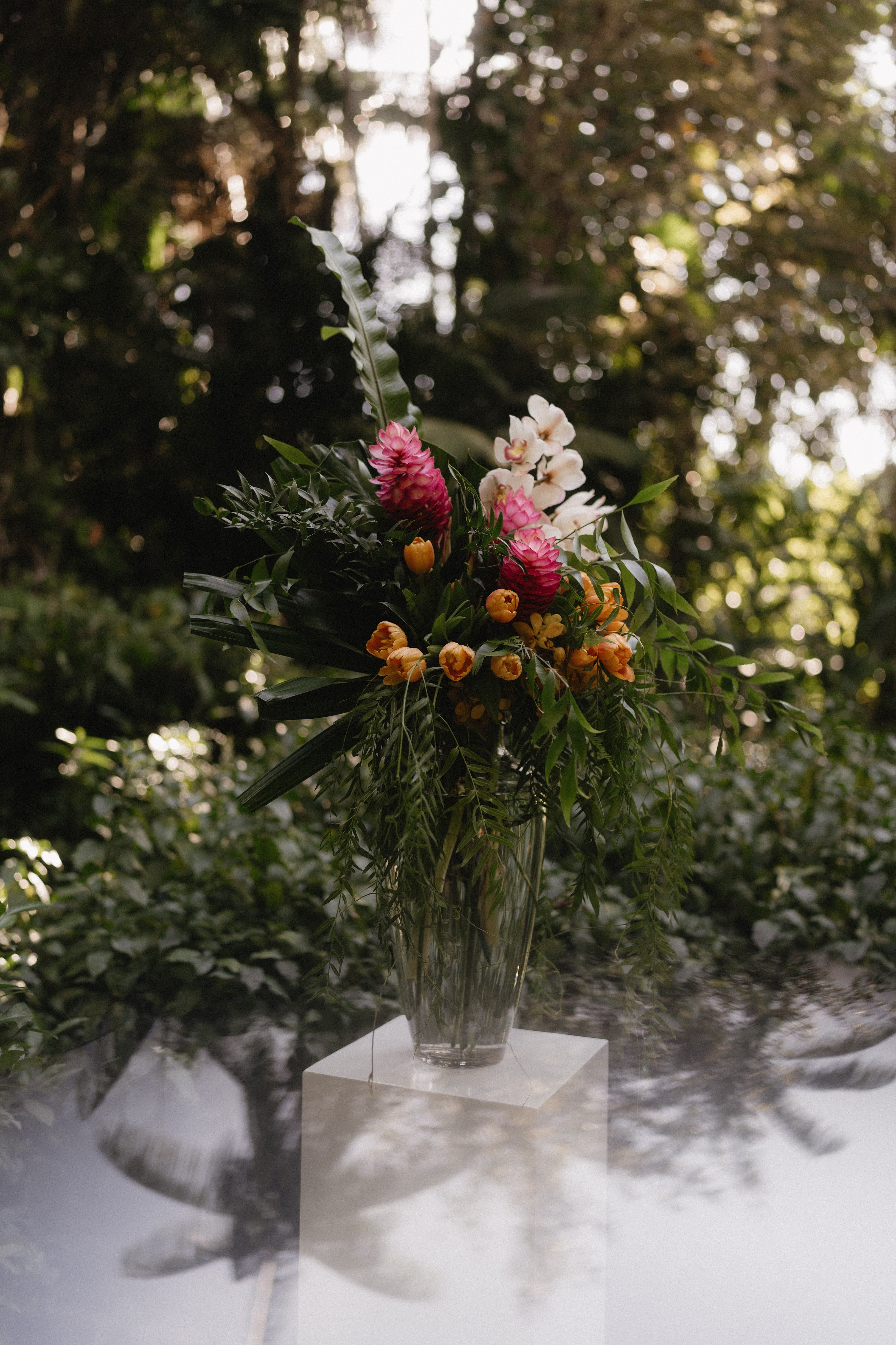 Floral arrangement in a clear vase on white plinth at the Darwin Botanic Gardens