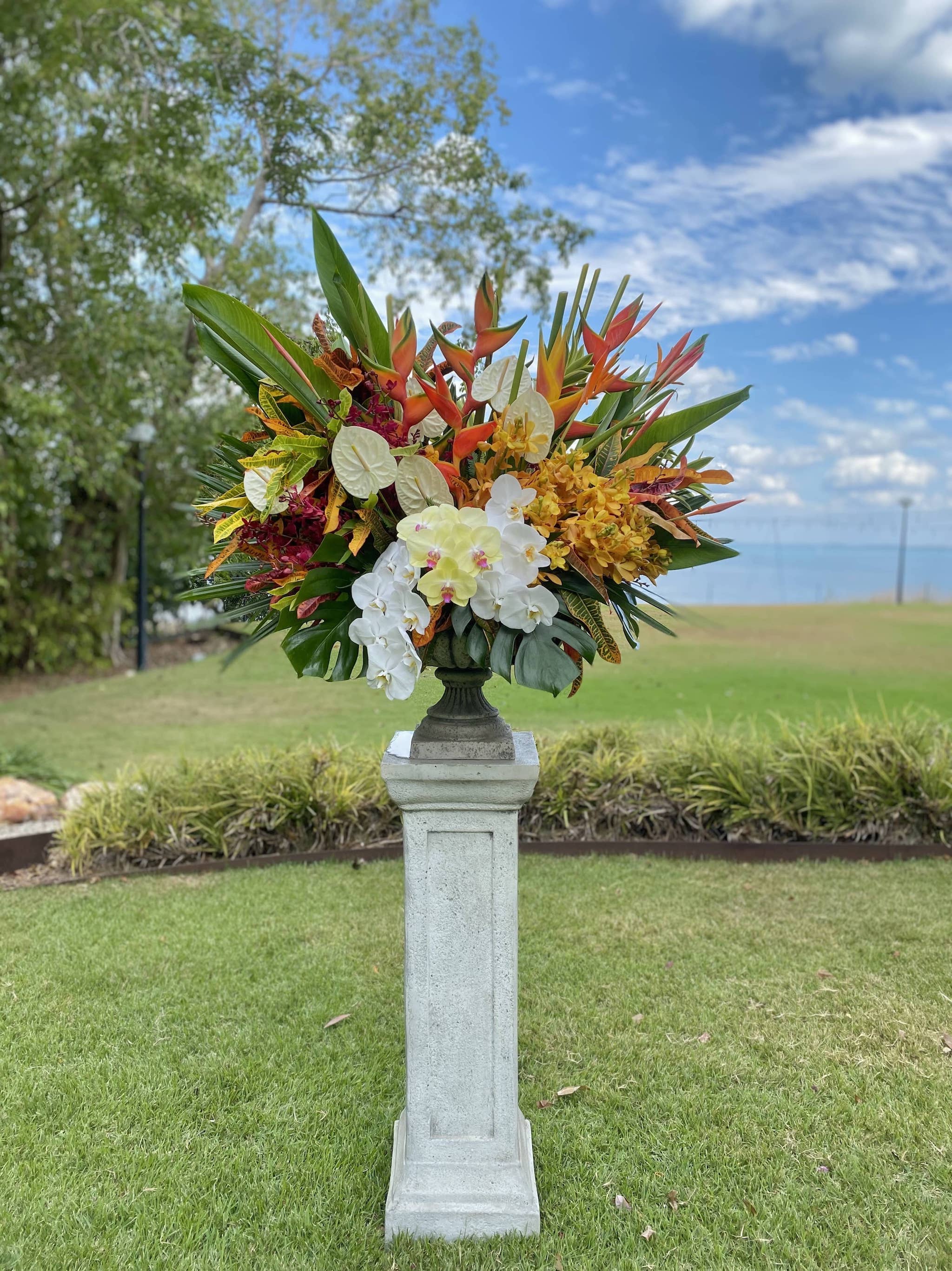Urn filled with tropical flowers at Pee Wees by the Point by Beija Flor Florist