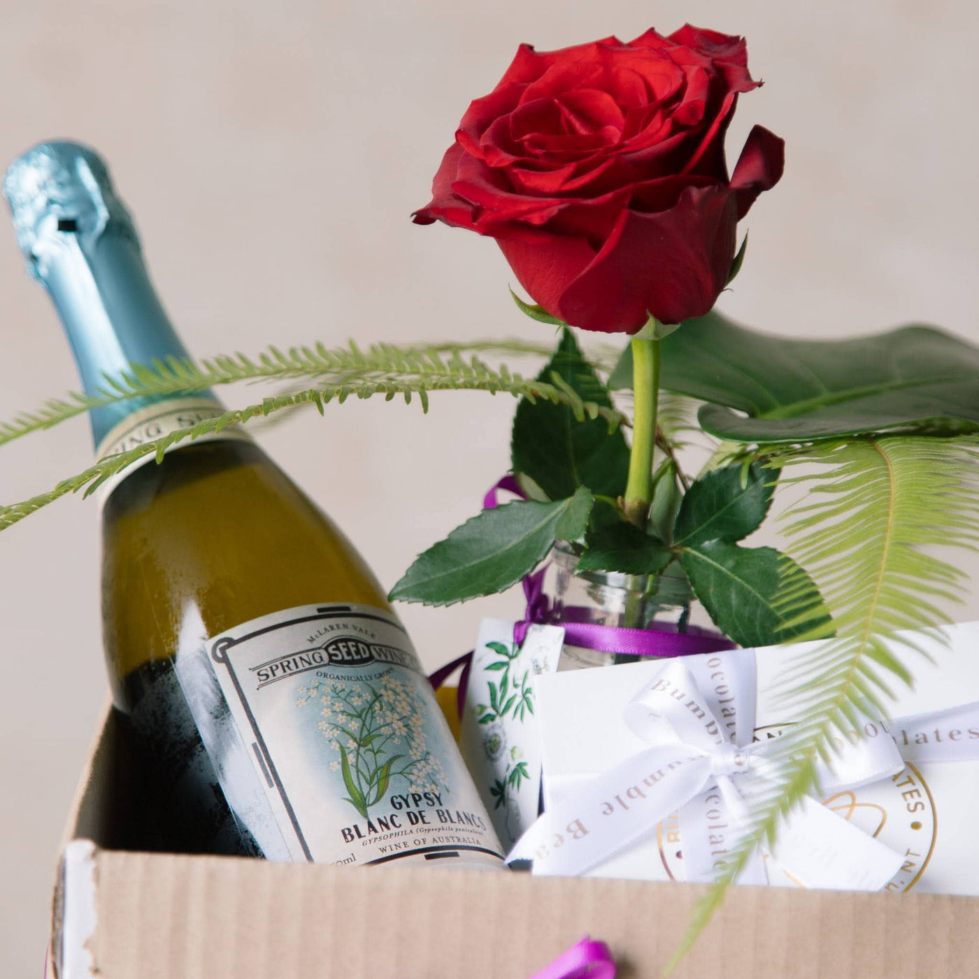 gift box with red rose, sparkling wine and chocolates