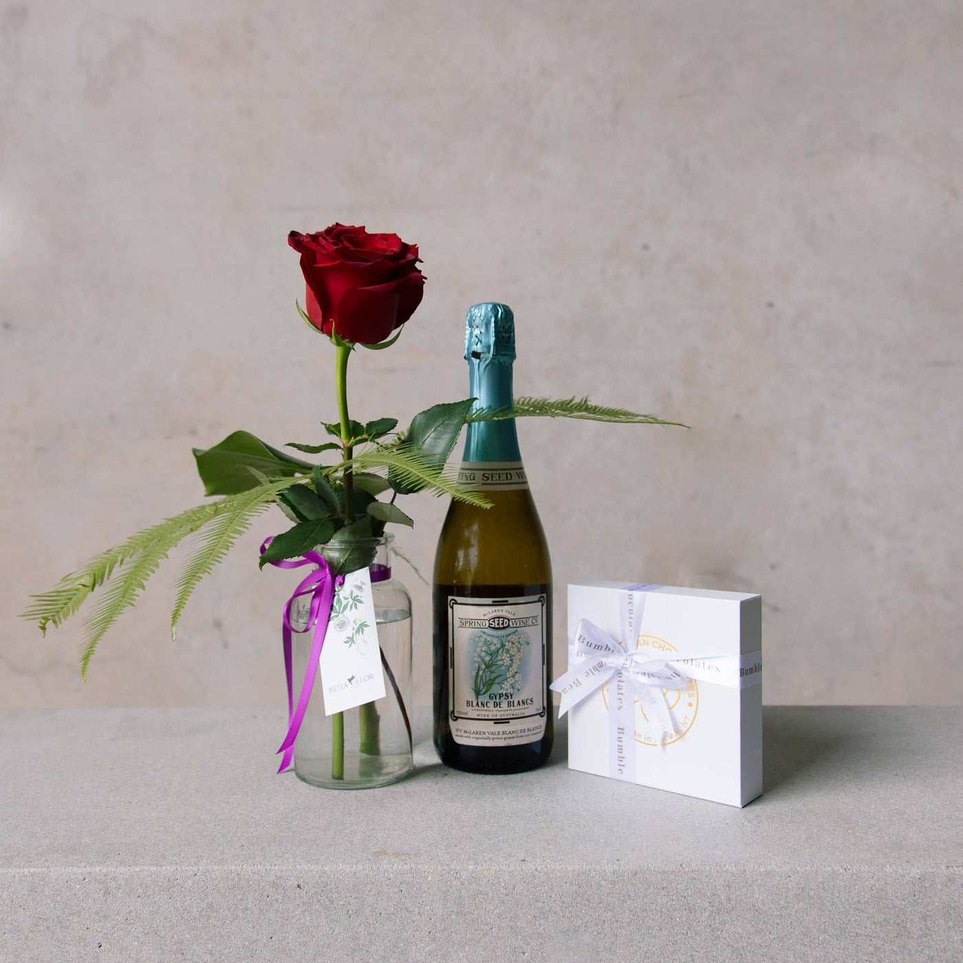 valentines day single rose in vase with sparkling wine and handcrafted chocolates